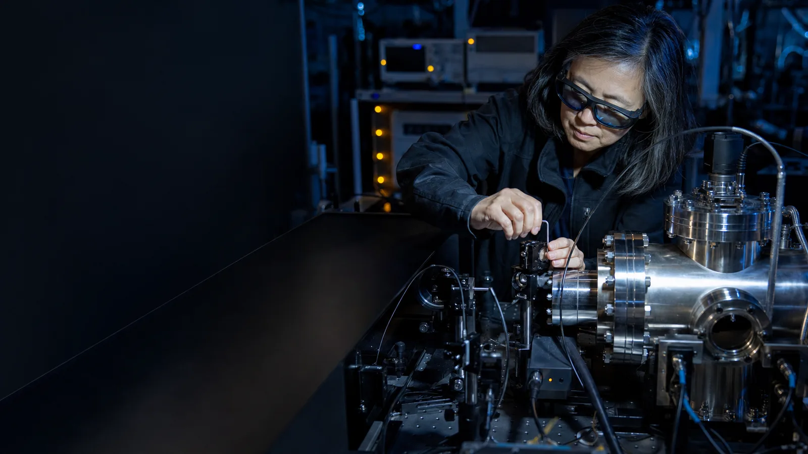 Editorial illustration of a physicist aligning optical equipment on a vacuum-lab bench.